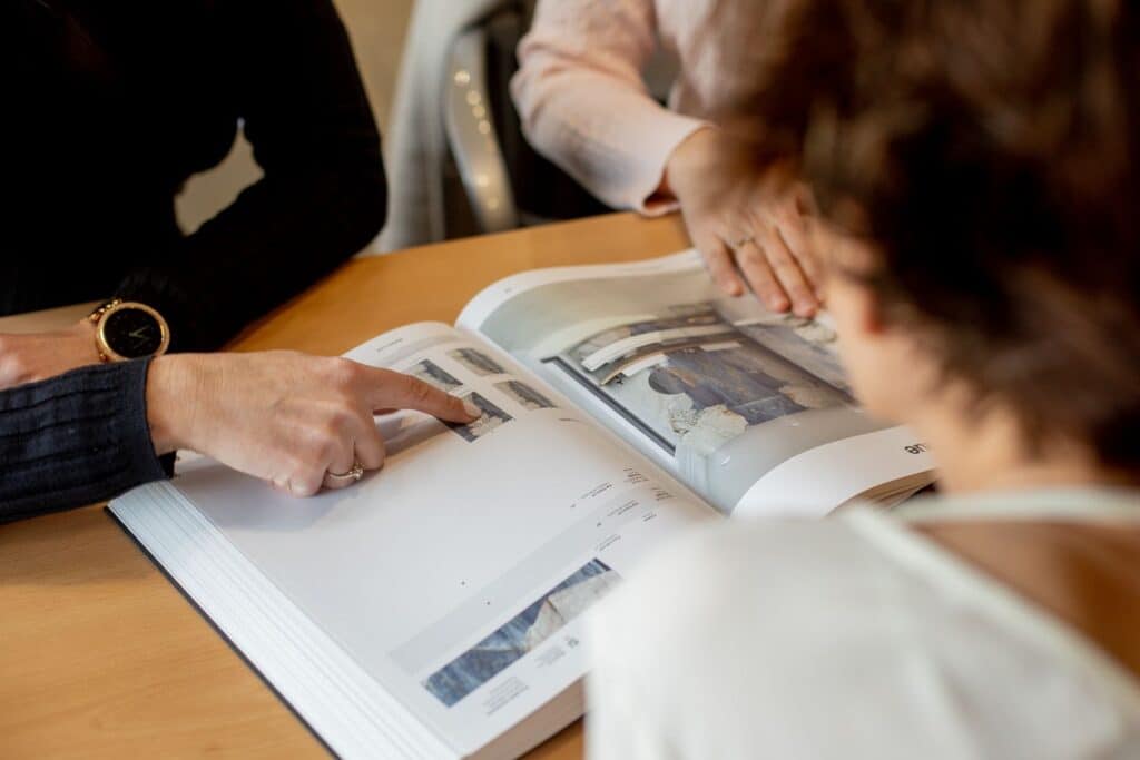 Client revisant un catàleg de materials durant la visita al showroom