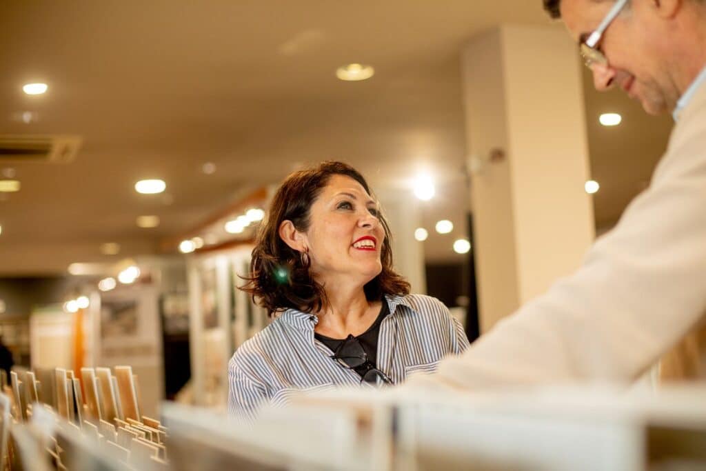 Assessora seleccionant mostres de ceràmica amb una clienta al showroom